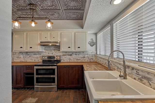 1437 Bowsprit Pt, Willis, TX 77318 - kitchen with double oven range, butcher block counters, extractor fan, and brick patterned flooring