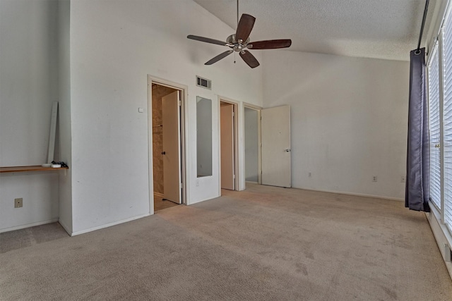 1437 Bowsprit Pt, Willis, TX 77318 - unfurnished bedroom with carpet floors, multiple windows, a textured ceiling, high vaulted ceiling, and ensuite bath