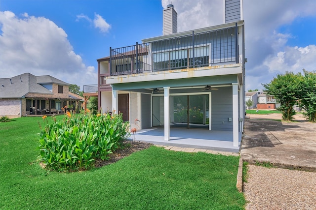 1437 Bowsprit Pt, Willis, TX 77318 - rear view of house featuring a balcony, a ceiling fan, a chimney, a lawn, and a patio