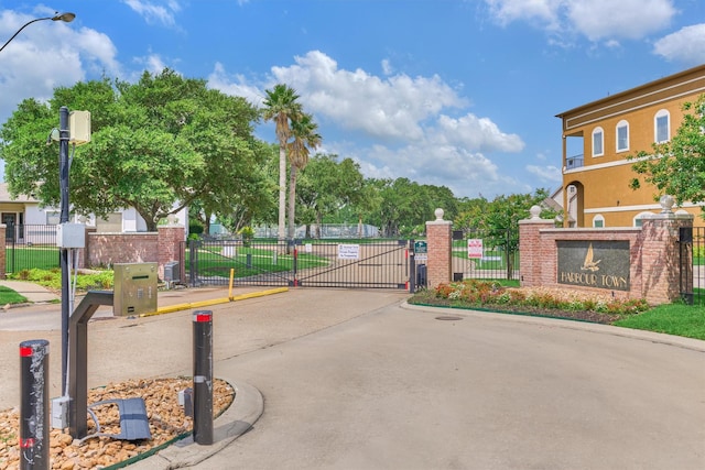 1437 Bowsprit Pt, Willis, TX 77318 - view of concrete street with street lights, a gate, curbs, and a gated entry