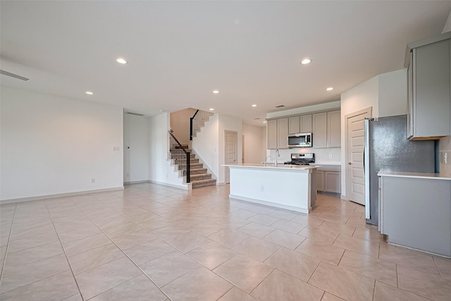 3943 Austins Pass, Katy, TX 77494 - kitchen with stainless steel microwave, gray cabinetry, light tile patterned floors, recessed lighting, and open floor plan