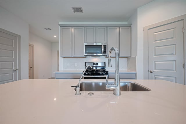 3943 Austins Pass, Katy, TX 77494 - kitchen with appliances with stainless steel finishes, gray cabinetry, light countertops, decorative backsplash, and recessed lighting