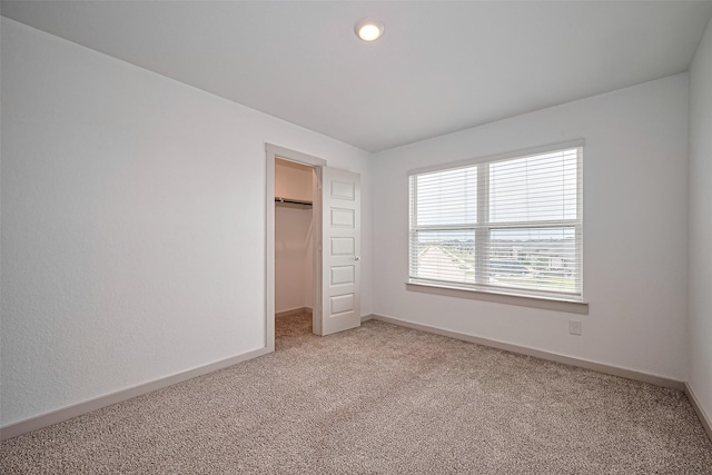 3943 Austins Pass, Katy, TX 77494 - unfurnished bedroom with light carpet, a walk in closet, and a closet