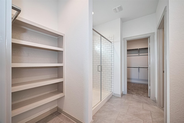 3943 Austins Pass, Katy, TX 77494 - bathroom with a walk in closet, a stall shower, and tile patterned floors