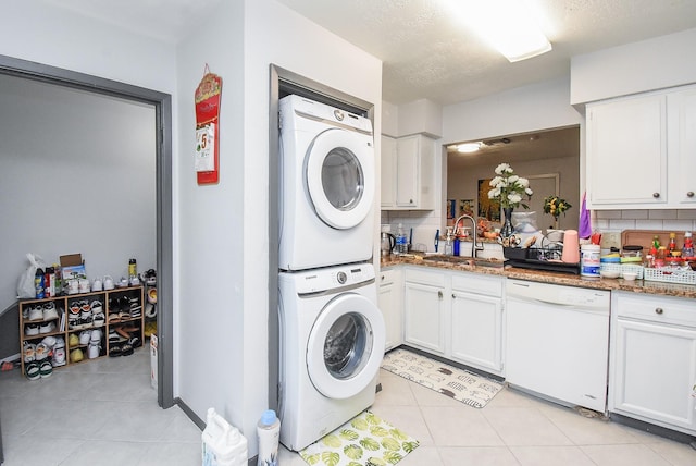 12469 Sharpview Dr Unit 2469, Houston, TX 77072 - washroom featuring estacked washer and dryer and light tile patterned floors