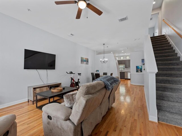 2710 Hullsmith Dr Unit 1004, Houston, TX 77063 - living room with stairs, ceiling fan, light wood-type flooring, and a chandelier