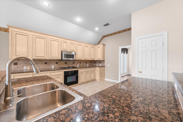 8722 Melting Shadows Ln, Houston, TX 77095 - kitchen featuring black oven, stainless steel microwave, cream cabinets, vaulted ceiling, and decorative backsplash