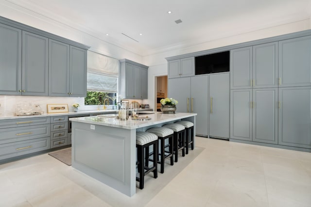2707 Westgrove Ln, Houston, TX 77027 - kitchen with a breakfast bar, a center island, gray cabinets, paneled fridge, and tasteful backsplash