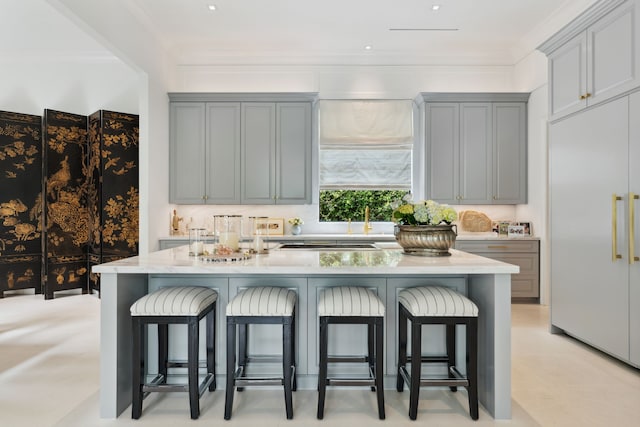 2707 Westgrove Ln, Houston, TX 77027 - kitchen with built in fridge, a kitchen breakfast bar, gray cabinetry, a center island, and ornamental molding
