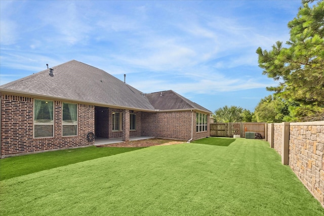 27722 Lakeway Trail Ln, Fulshear, TX 77441 - back of house featuring a shingled roof, a fenced backyard, brick siding, and a patio