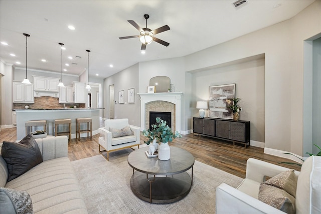 27722 Lakeway Trail Ln, Fulshear, TX 77441 - living area with light wood finished floors, ceiling fan, recessed lighting, and a fireplace