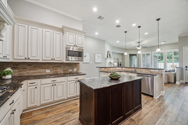 27722 Lakeway Trail Ln, Fulshear, TX 77441 - kitchen featuring appliances with stainless steel finishes, a kitchen island with sink, recessed lighting, decorative backsplash, and light wood finished floors