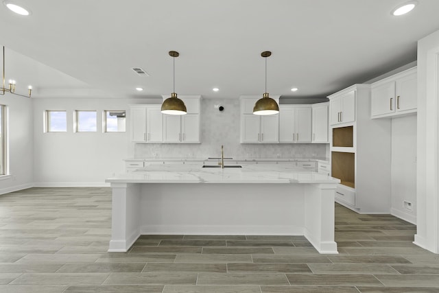 10922 Palmwood Dr, Missouri City, TX 77459 - kitchen featuring light wood finished floors, a spacious island, white cabinetry, decorative backsplash, and recessed lighting