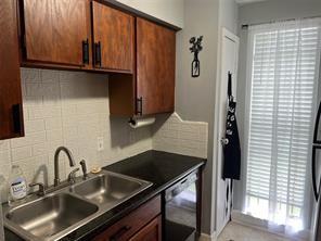 12500 Sandpiper Dr Unit 57, Houston, TX 77035 - kitchen with dishwashing machine, backsplash, and dark countertops