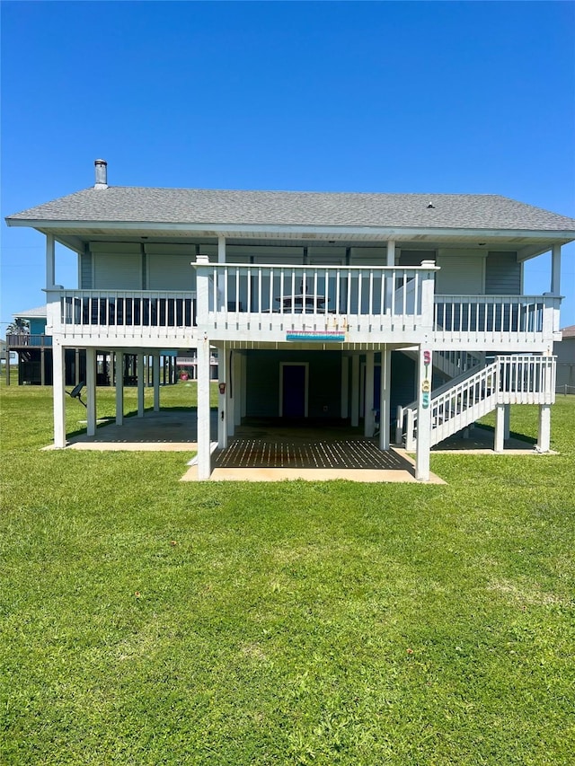 3185 Sea Castle Dr, Crystal Beach, TX 77650 - rear view of property featuring roof with shingles, a lawn, and a deck