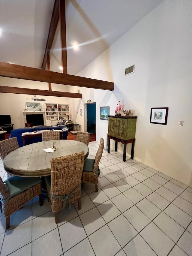 3185 Sea Castle Dr, Crystal Beach, TX 77650 - dining room featuring high vaulted ceiling, light tile patterned flooring, a fireplace, and beamed ceiling