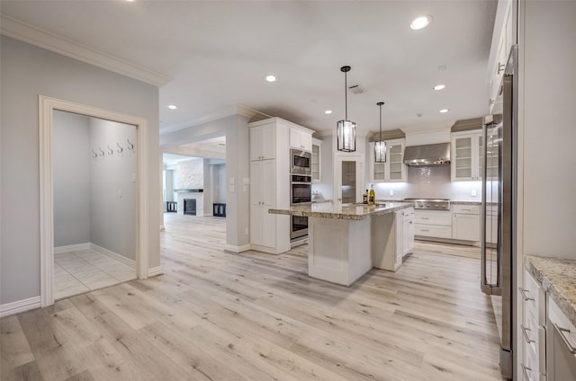 13619 Teal Bluff Ln, Houston, TX 77077 - kitchen featuring wall chimney exhaust hood, ornamental molding, a breakfast bar, stainless steel appliances, and light stone countertops
