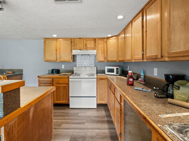 19995 Fm 92 S, Fred, TX 77616 - kitchen with white appliances, under cabinet range hood, dark wood finished floors, recessed lighting, and a textured ceiling