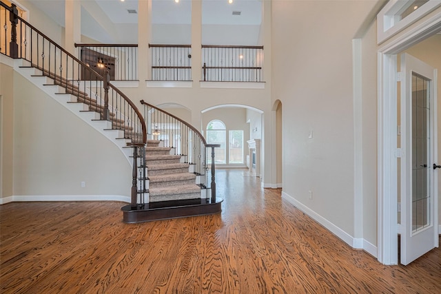 9 Foxworth Ct, Sugar Land, TX 77479 - foyer entrance featuring arched walkways, wood finished floors, stairway, and a high ceiling