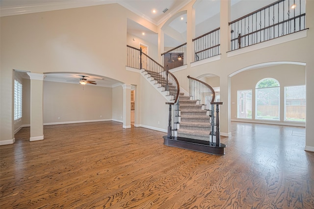 9 Foxworth Ct, Sugar Land, TX 77479 - foyer with a ceiling fan, wood finished floors, arched walkways, a high ceiling, and stairs