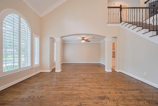 9 Foxworth Ct, Sugar Land, TX 77479 - empty room featuring ornate columns, a ceiling fan, wood finished floors, high vaulted ceiling, and arched walkways