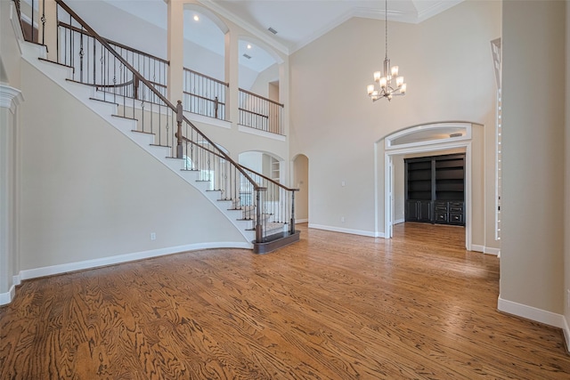 9 Foxworth Ct, Sugar Land, TX 77479 - entrance foyer with wood finished floors, stairway, arched walkways, ornamental molding, and a chandelier