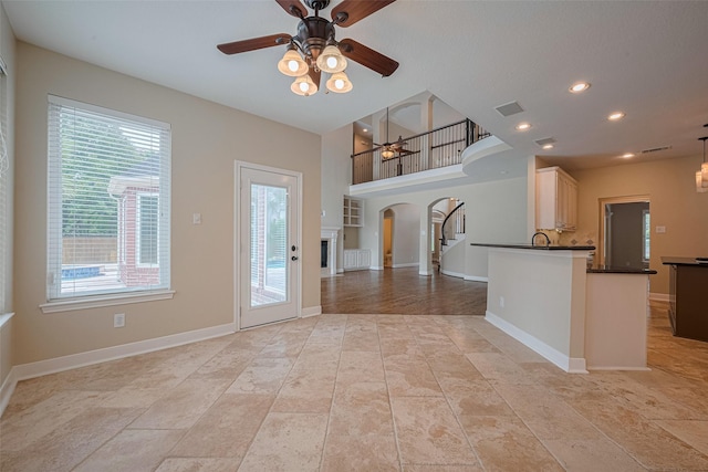 9 Foxworth Ct, Sugar Land, TX 77479 - kitchen featuring ceiling fan, arched walkways, dark countertops, plenty of natural light, and recessed lighting