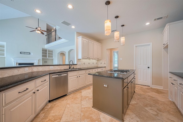 9 Foxworth Ct, Sugar Land, TX 77479 - kitchen featuring appliances with stainless steel finishes, a ceiling fan, tasteful backsplash, a fireplace, and recessed lighting