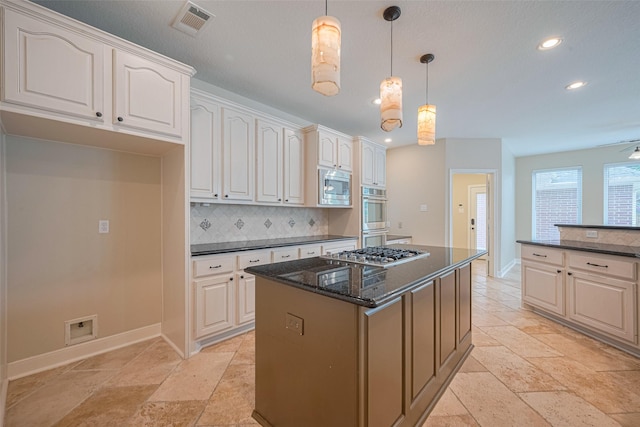 9 Foxworth Ct, Sugar Land, TX 77479 - kitchen featuring appliances with stainless steel finishes, backsplash, recessed lighting, dark stone countertops, and a kitchen island