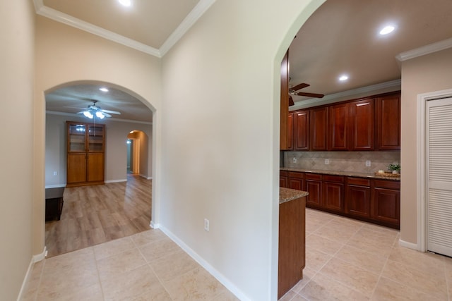 5242 Garnetfield Ln, Katy, TX 77494 - kitchen featuring ceiling fan, arched walkways, crown molding, decorative backsplash, and light tile patterned flooring