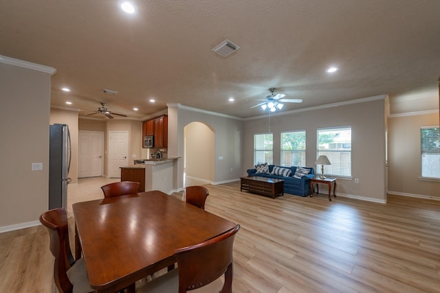 5242 Garnetfield Ln, Katy, TX 77494 - dining room with a ceiling fan, arched walkways, recessed lighting, crown molding, and light wood-style floors