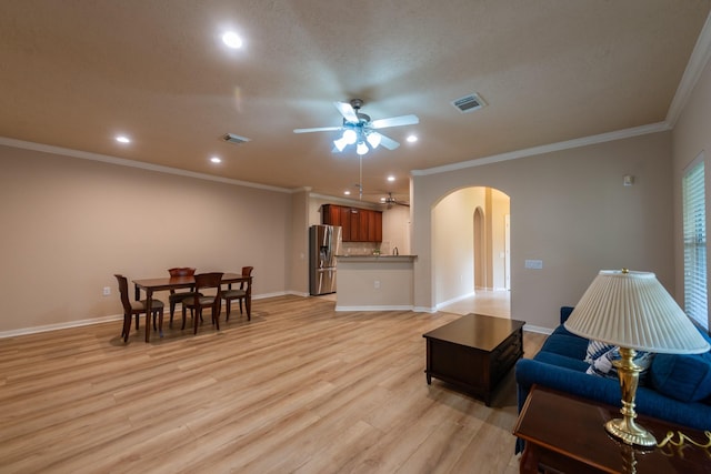5242 Garnetfield Ln, Katy, TX 77494 - living room with arched walkways, ceiling fan, crown molding, light wood-style floors, and recessed lighting
