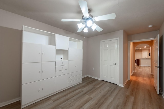 5242 Garnetfield Ln, Katy, TX 77494 - unfurnished bedroom featuring arched walkways, light wood finished floors, and ceiling fan