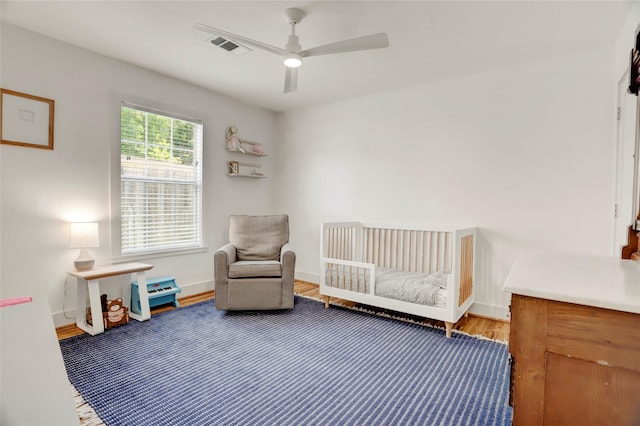 1039 Lamonte Ln, Houston, TX 77018 - bedroom with wood finished floors, a crib, and ceiling fan