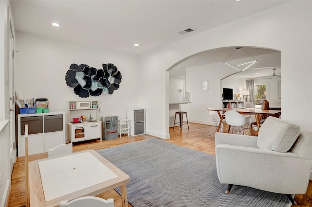 1039 Lamonte Ln, Houston, TX 77018 - living room featuring arched walkways, light wood-style floors, and recessed lighting