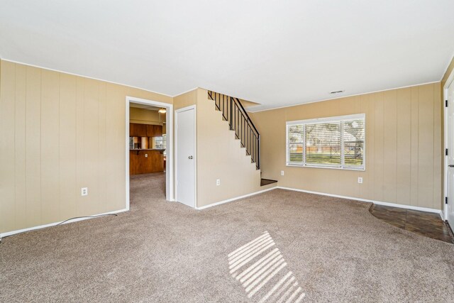 5302 Pine Ave, Pasadena, TX 77503 - unfurnished living room with stairway, carpet floors, and wooden walls