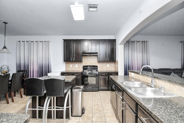 14710 Branchwest Dr, Houston, TX 77082 - kitchen with black range with gas cooktop, arched walkways, under cabinet range hood, decorative backsplash, and a kitchen bar
