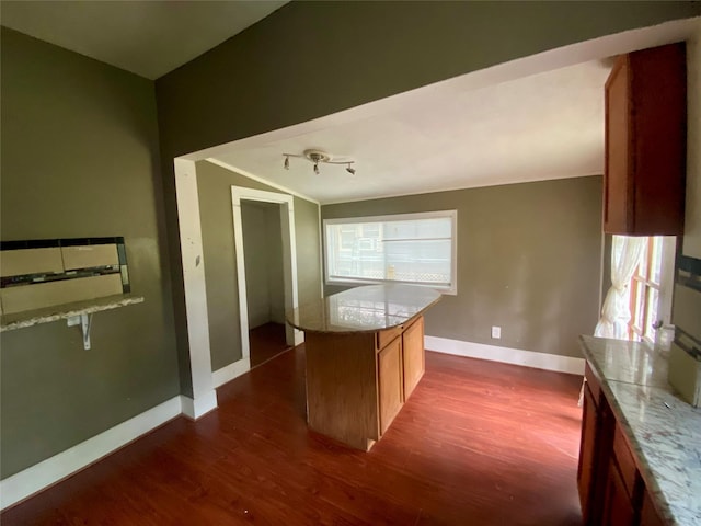212 Harding Ave, Cleveland, TX 77327 - kitchen with dark wood-type flooring, light stone counters, a kitchen island, and brown cabinets