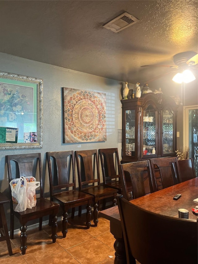 11733 Knotty Pine Trl, Houston, TX 77050 - tiled dining room with ceiling fan, a textured ceiling, and a textured wall