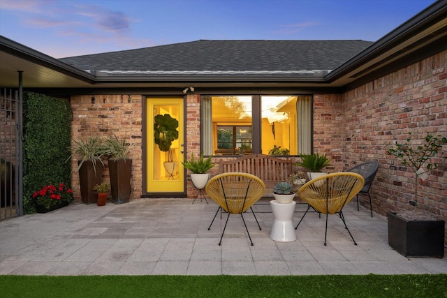 9718 Checkerboard St, Houston, TX 77096 - property entrance featuring a shingled roof, a patio area, and brick siding