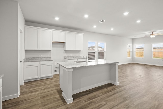 316 Amy St, Angleton, TX 77515 - kitchen featuring white cabinets, recessed lighting, a kitchen island with sink, dark wood-style flooring, and light stone counters