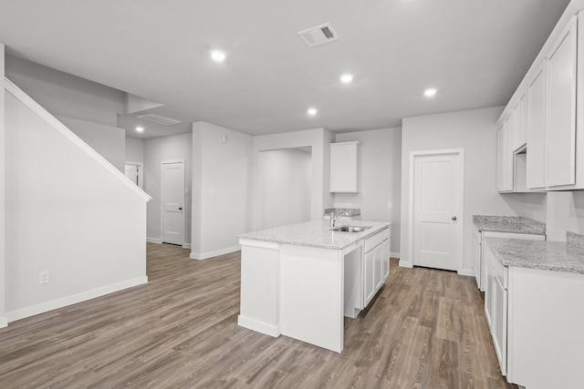 316 Amy St, Angleton, TX 77515 - kitchen with a center island with sink, light wood-style flooring, recessed lighting, light stone counters, and white cabinets