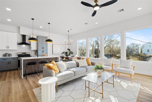 6907 Conley St, Houston, TX 77021 - living room featuring light wood finished floors, a ceiling fan, recessed lighting, and a chandelier