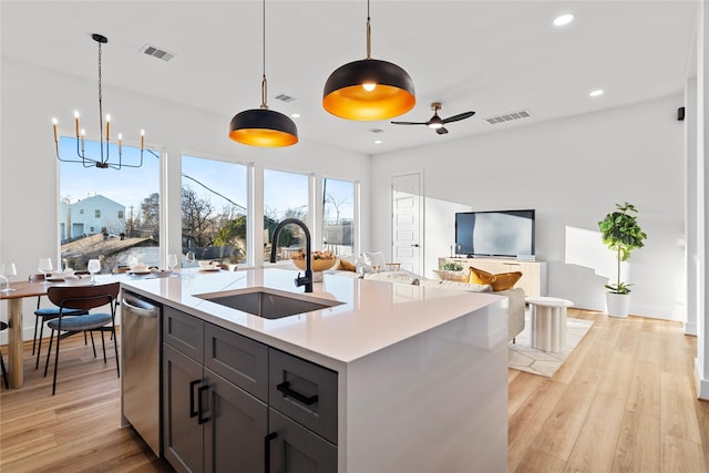 6907 Conley St, Houston, TX 77021 - kitchen featuring light countertops, stainless steel dishwasher, light wood finished floors, open floor plan, and hanging light fixtures