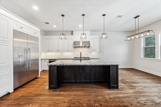 1901 Woodcrest Dr, Houston, TX 77018 - kitchen featuring stainless steel built in refrigerator, range hood, tasteful backsplash, dark wood-style flooring, and white cabinets