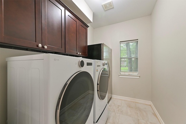 15431 Greens Cove Way, Houston, TX 77059 - washroom with cabinet space, washer and clothes dryer, and light marble finish floors