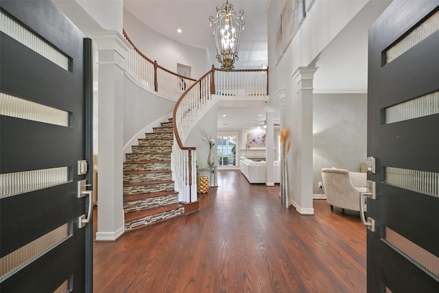 15431 Greens Cove Way, Houston, TX 77059 - entrance foyer with a high ceiling, stairs, wood finished floors, a chandelier, and decorative columns