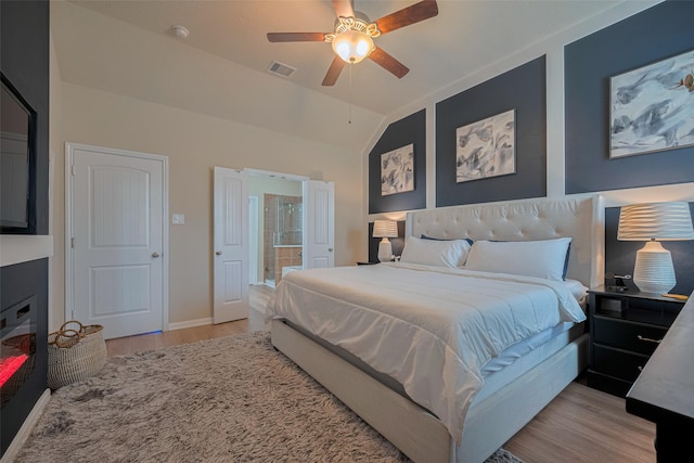 8113 E Pine Creek Bnd, Cypress, TX 77433 - bedroom featuring light wood-style floors, connected bathroom, vaulted ceiling, and ceiling fan