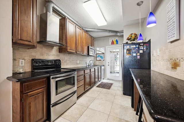 1018 Memorial Village Dr Unit 124, Houston, TX 77024 - kitchen featuring stainless steel appliances, wall chimney range hood, decorative backsplash, a textured ceiling, and light tile patterned floors