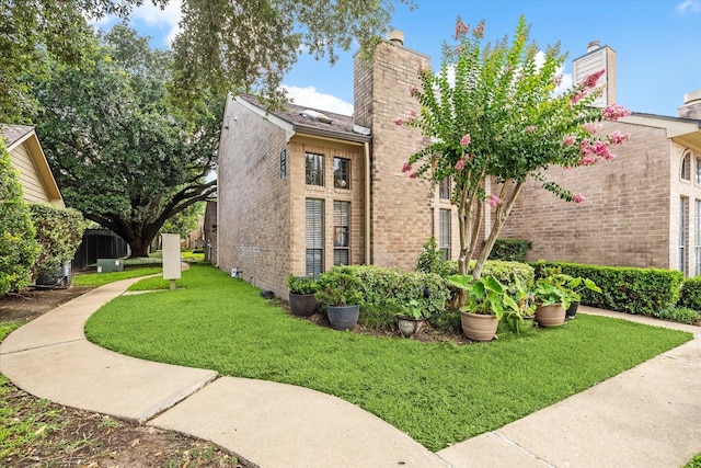 1018 Memorial Village Dr Unit 124, Houston, TX 77024 - view of property exterior with brick siding, a chimney, and a lawn